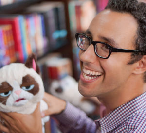 مصمم الدمى، زاك بوخمان في حدث عام، يحمل دمية القط العابس