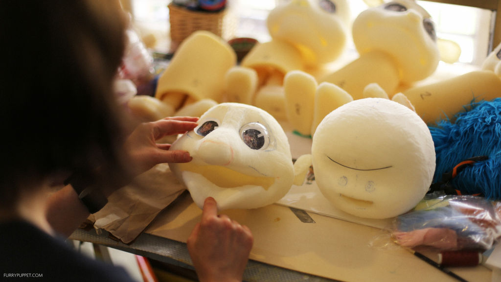 Artist Maria Gurevich examines some newly born puppet heads.