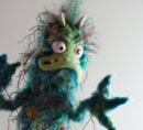 Monster puppet inspired by a bacteria, with wild expression and green fur