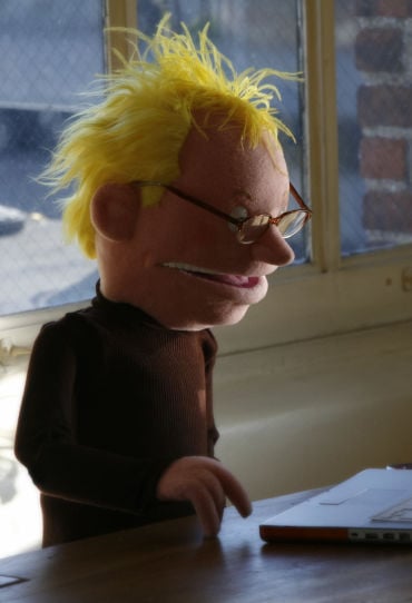 Nerdy puppet guy, working on his laptop