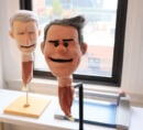 Lil Andy and Anderson Cooper puppet heads on display.