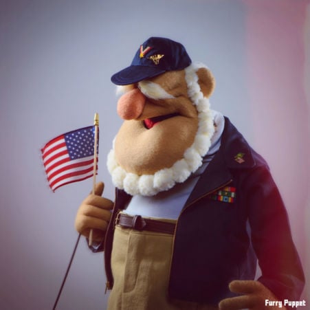 Custom puppet of an old veteran wearing a baseball hat and waving the American flag