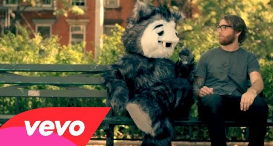 Mascot costume sitting on a bench together with American Authors band member