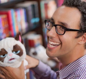 Puppet Designer, Zack Buchman at a public event, holding a Grumpy Cat puppet