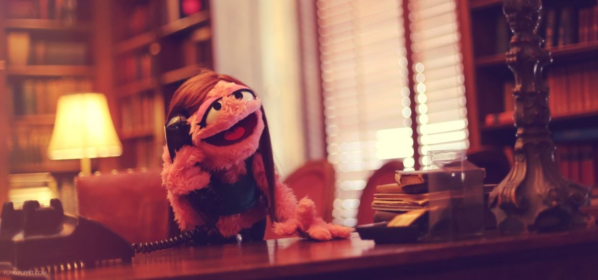 Pink puppet in an old fashioned office, talking on the telephone